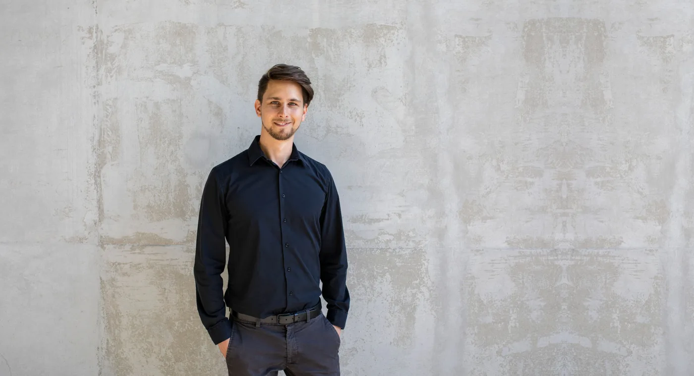 Pascal Pfammatter, founder of Mirific, standing against a concrete wall